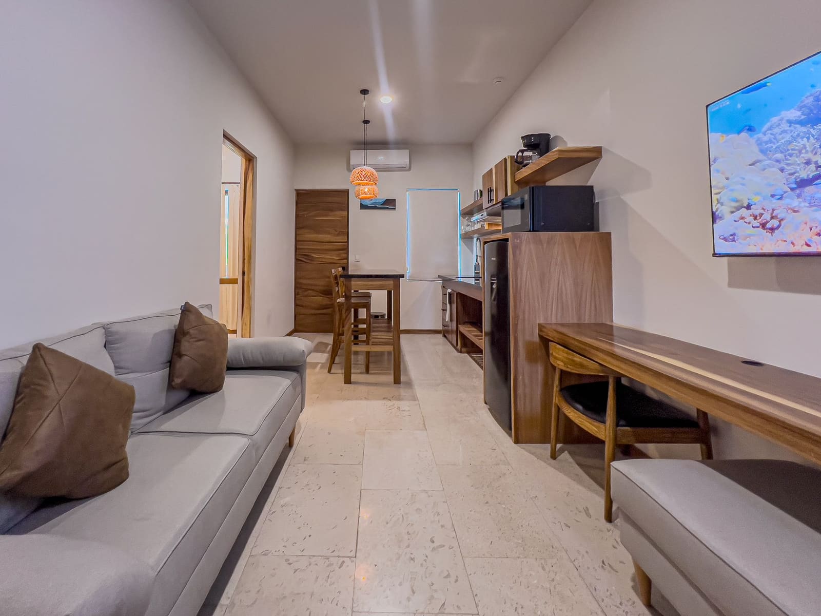 Suite living room, kitchen and dining area, with the bedroom and bathroom doors beyond